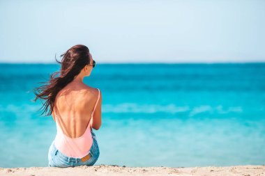 Plajda genç ve güzel bir kadın tropikal yaz tatilinde