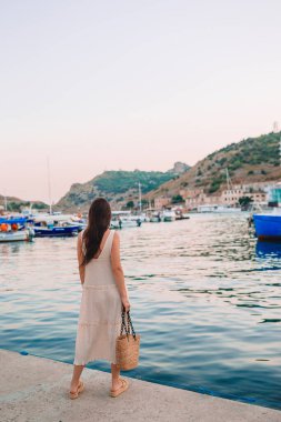 dock yakınındaki tekne üzerinde yürüyen genç güzel kadın 