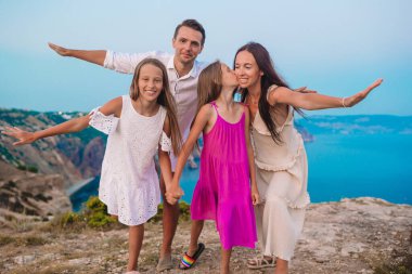 Mutlu dört kişilik aile gün batımında dağlarda yürüyor.