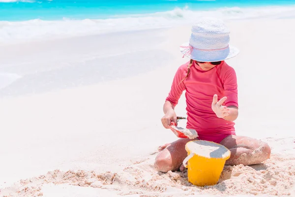 Klein meisje op tropisch wit strand maken zand kasteel — Stockfoto