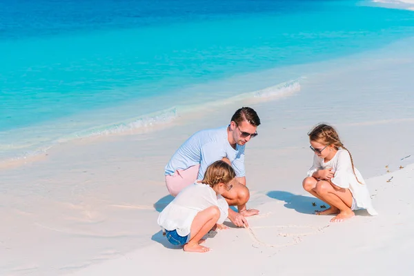 Mutlu baba ve onun sevimli küçük kızları tropik sahilde eğleniyorlar. — Stok fotoğraf