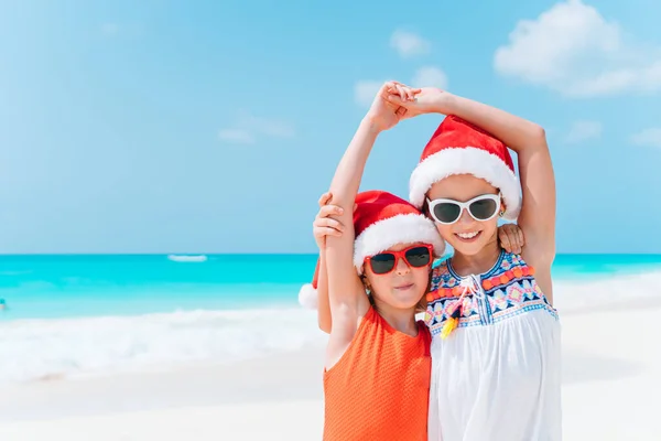 Adorable little girls with starfish on white empty beach — Stock Photo, Image