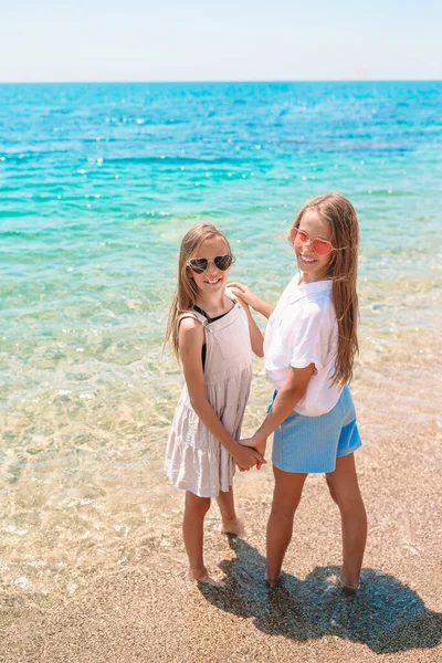 Little happy funny girls have a lot of fun at tropical beach playing together — Stock Photo, Image