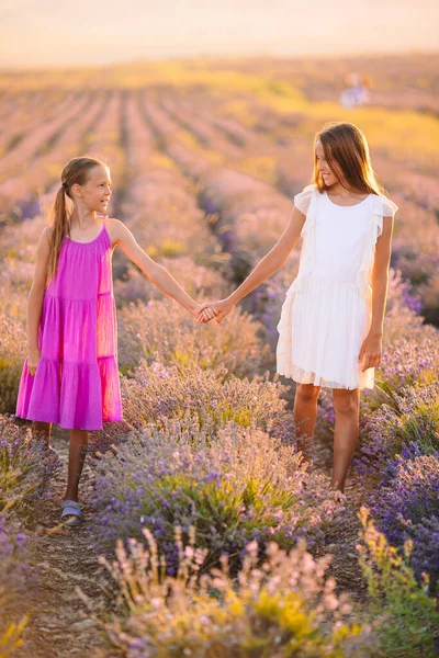 Mädchen im Lavendelblütenfeld bei Sonnenuntergang im weißen Kleid — Stockfoto