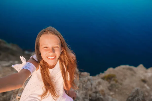 Klein meisje op de top van een berg genietend van vallei uitzicht voor zonsondergang — Stockfoto