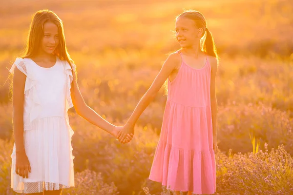 Meninas no campo de flores de lavanda ao pôr do sol em vestido branco — Fotografia de Stock