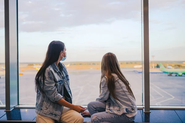 Madre e bambina con maschere mediche all'aeroporto. Protezione contro Coronavirus e impugnatura — Foto Stock