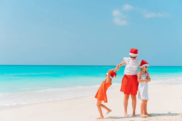 Rozkošné holčičky a mladá matka na tropické bílé pláži na vánoční dovolenou — Stock fotografie