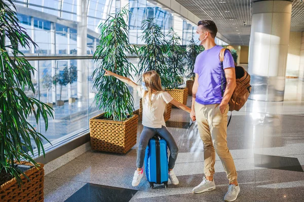 Dad and little girl with medical masks at airport. Protection against Coronavirus and gripp — Stock Photo, Image