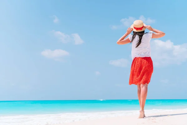 Genç ve güzel bir kadın tropik deniz kıyısında eğleniyor. Mutlu kız arka planda mavi gökyüzü ve denizdeki turkuaz su — Stok fotoğraf
