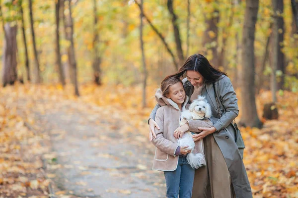 Little girl with mom outdoors in park at autumn day — Stock Photo, Image