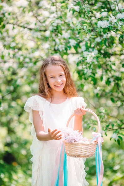 Liebenswertes kleines Mädchen im blühenden Apfelgarten an einem schönen Frühlingstag — Stockfoto