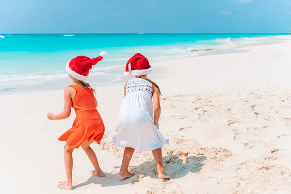 Adorable little girls with starfish on white empty beach — Stock Photo, Image