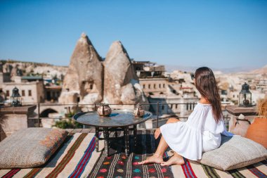 Güneş doğarken Kapadokya, Türkiye 'de sıcak hava balonları seyreden mutlu genç kadın