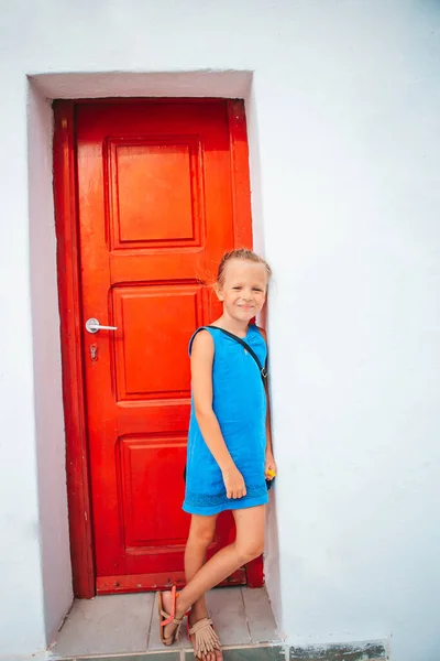 Adorable niña en la vieja calle del típico pueblo tradicional griego —  Fotos de Stock