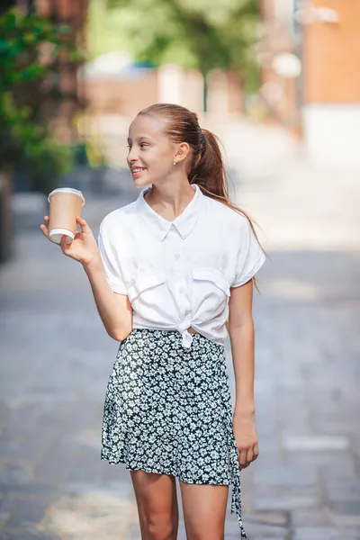 Kleines lächelndes Mädchen spielt und umarmt Welpen im Park — Stockfoto