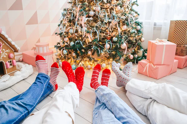 Feche a foto de pés de família em meias de lã pela árvore de Natal — Fotografia de Stock