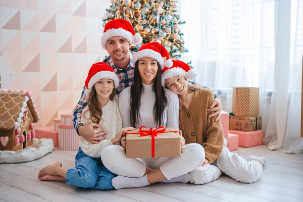 Feliz familia joven con niños sosteniendo regalos de Navidad — Foto de Stock