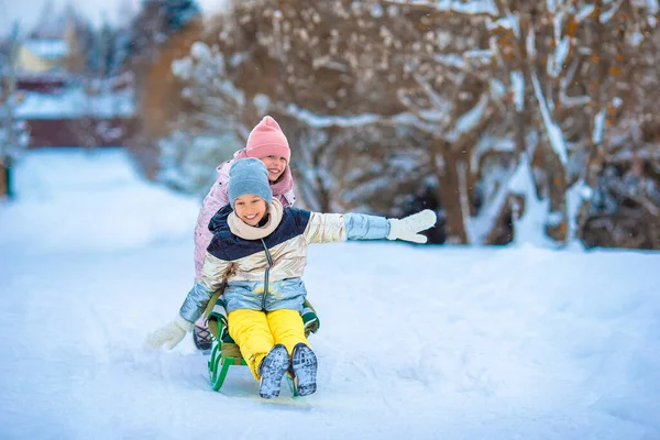 Adorable poco feliz niñas trineo en invierno nevado día . — Foto de Stock