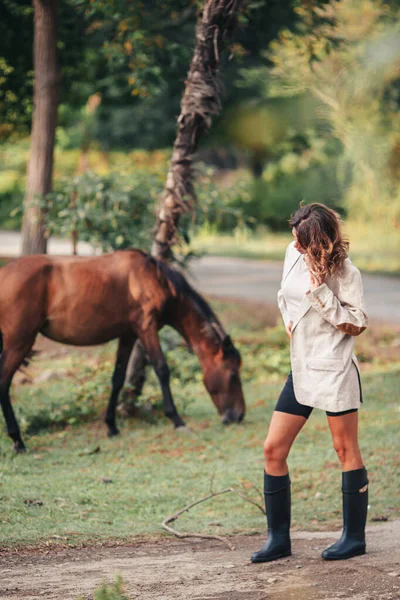 Young woman with wild horse outdoors — Stock Photo, Image