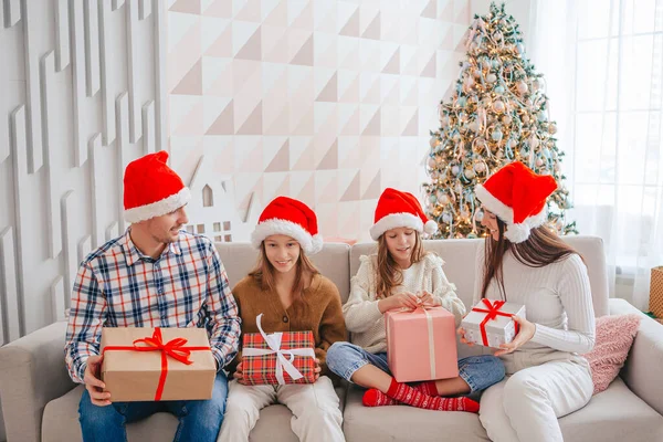 Feliz familia joven con niños sosteniendo regalos de Navidad —  Fotos de Stock