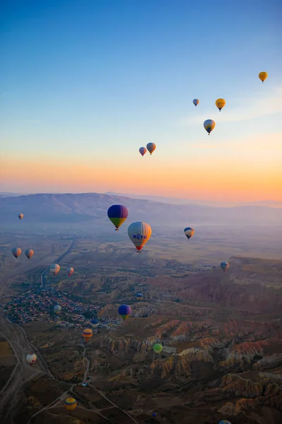 Hőlégballon repül át sziklás tájak Cappadocia gyönyörű ég a háttérben — Stock Fotó