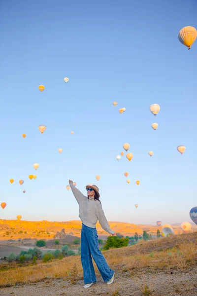 Happy woman during sunrise watching hot air balloons in Cappadocia, Turkey — Stock Photo, Image