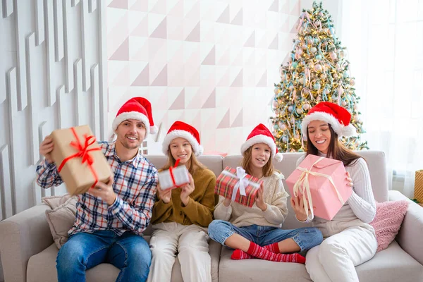 Feliz familia joven con niños sosteniendo regalos de Navidad — Foto de Stock