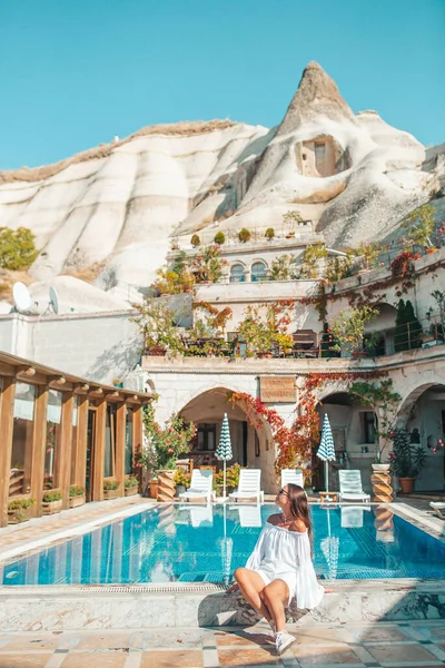 Mulher bonita à beira da piscina em um hotel com quartos na rocha na Capadócia — Fotografia de Stock