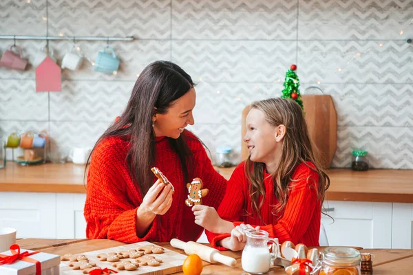 Family of mom and daughter prepare Christmas cookies on the kitchen