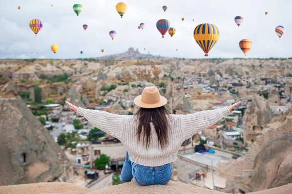 Gelukkige jonge vrouw tijdens zonsopgang kijken naar hete lucht ballonnen in Cappadocia, Turkije — Stockfoto
