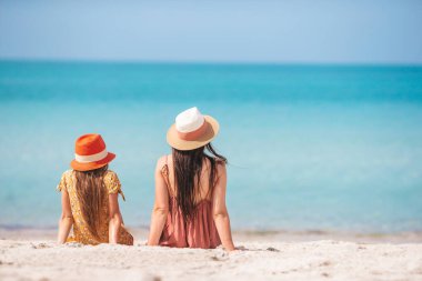 Family of mother and daughter relax on the beach