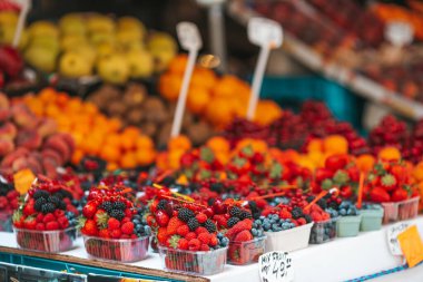 Fruits and berries on the street market. Blueberries, raspberries, strawberries, cherries and blackberries on the market. Gardening, agriculture, harvest and forest concept.