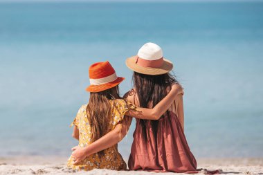 Family of mother and daughter relax on the beach