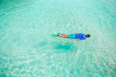 Man snorkeling in the clear turquoise ocean on Maldives