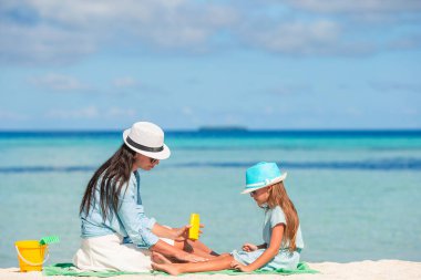 Genç kızın burnuna sahilde uygulanan güneş kremi anne. Ultraviyole radyasyon koruma kavramı