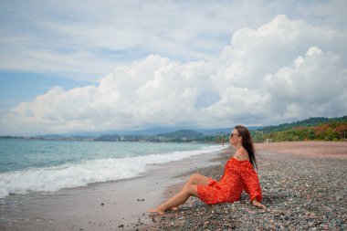 Genç ve güzel bir kadın beyaz kumsalda