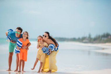 Family of four on the beach vacation going to swim