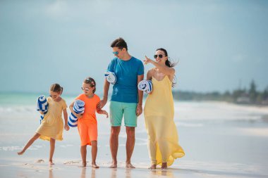 Family of four on the beach vacation going to swim