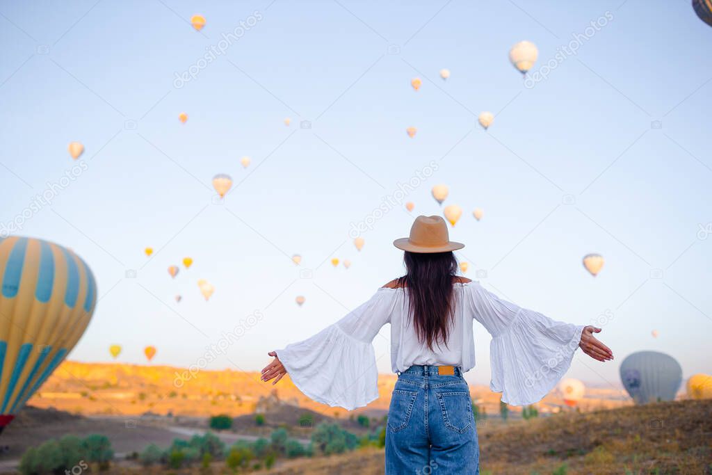 Happy woman in Cappadocia. Young tourist travels the world. Hot air balloon flights.