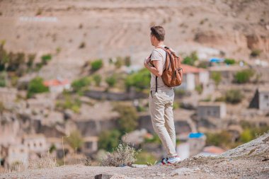 Kapadokya 'daki genç turist. Türkiye 'nin Kapadokya kentindeki Goreme' de arka planda hava balonları olan beyaz bir adam.