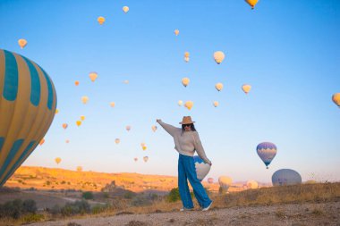 Kapadokya 'daki mutlu kadın. Genç turistler dünyayı gezer. Sıcak hava balonu uçuşları.