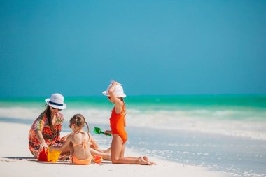 Tropik sahilde kumdan kale yapan bir aile. Aile yaz tatilinde birlikte vakit geçirir.