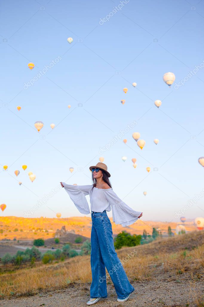 Happy woman in Cappadocia. Young tourist travels the world. Hot air balloon flights.