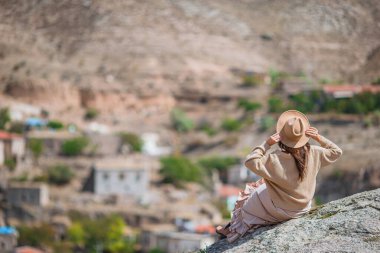 Young woman on background of ancient cave formations in Cappadocia, Turkey.