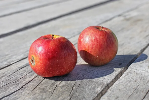 Červená jablka na dřevěném pozadí — Stock fotografie
