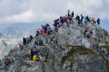 Polonya 'nın en yüksek zirvesi olan dar ve kayalık Rysy Tepesi' nde (250 metre) Slovakya sınırında turist ve yürüyüşçü kalabalığı var. Yüksek Tatras, Polonya - 14 Ağustos 2021.