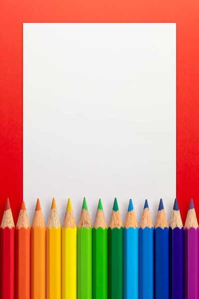 Függőleges Keret Készült Színes Ceruzák Fehér Könyv Egy Piros Háttér — Stock Fotó