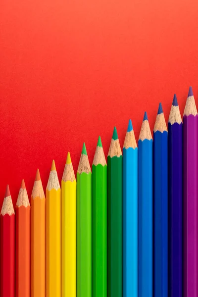 Цветные Карандаши Расположены Диагонали Красном Вертикальном Бумажном Фоне — стоковое фото