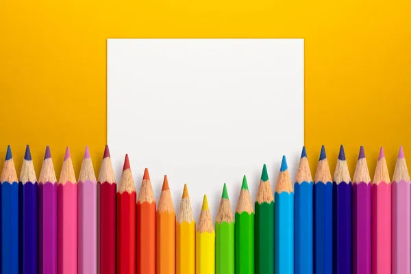 ホワイトペーパーカードノートで黄色の紙の背景に色鉛筆で作られた創造的なレイアウト 平置きだ 教育理念 — ストック写真